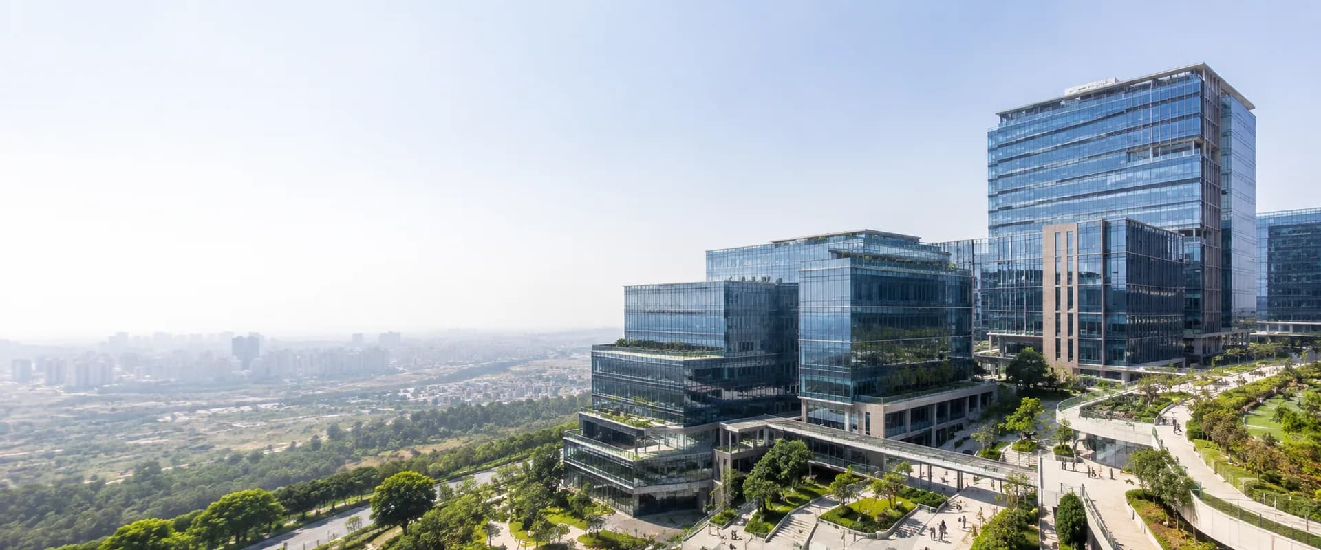Elevated view of a modern corporate campus of linked glass office blocks and landscaped courtyards